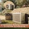 Cache clim DECOAirco L design intégré dans un jardin devant un mur en pierre